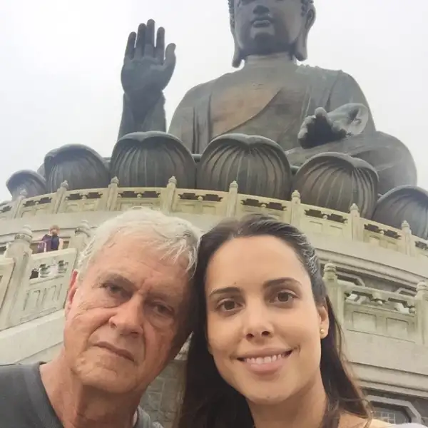 Vanesa y su papá con el Tian Tan a sus espaldas.