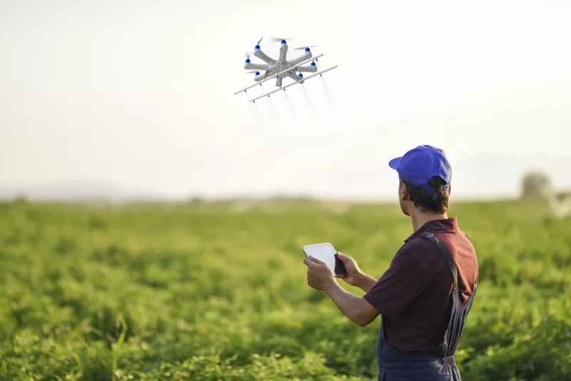 Farmer spraying his crops using a drone