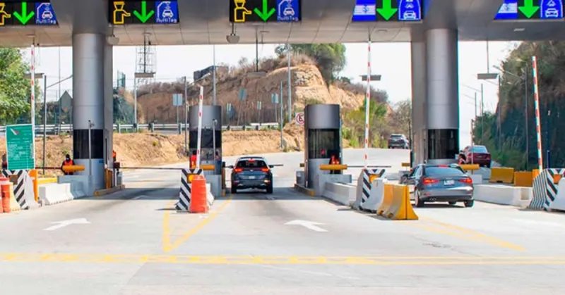 Casetas en una carretera de México en donde hay dos carros pasando.jpg