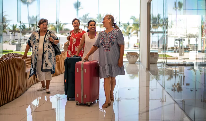 Senior friend arriving at a hotel with their luggage
