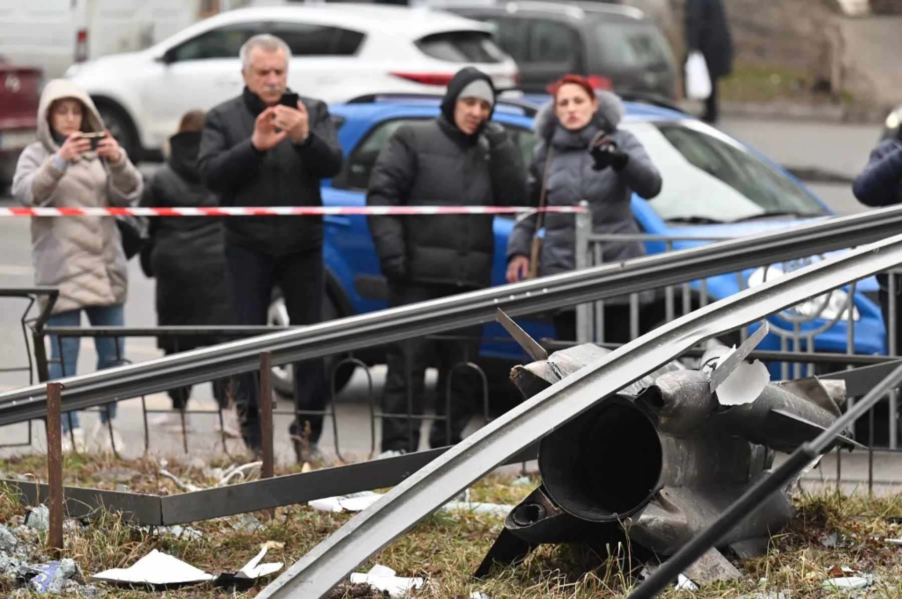 Personas en Kiev reaccionan al rededor de los restos de un misil. 