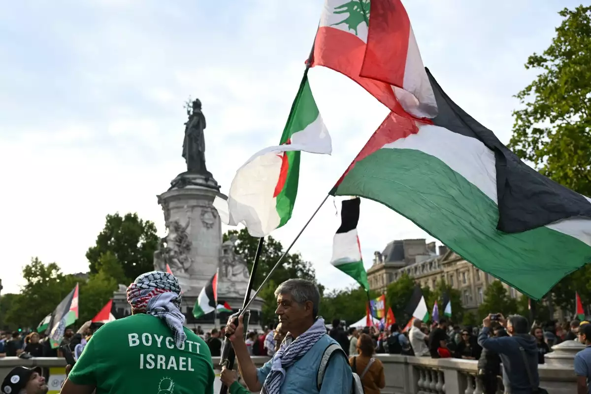 Un hombre sostiene las banderas argelina (Izquierda), libanesa (arriba) y palestina durante una manifestación pro-palestina contra las acciones de Israel y la actual escasez de alimentos en la Franja de Gaza, y para dar la bienvenida a las actividades liberadas del barco de la Flotilla de la Libertad Handala en la Place de la Rpublique en París el 29 de julio de 2025. Más de una docena de activistas detenidos por Israel después de que su barco de ayuda fuera interceptado de camino a Gaza lanzaron una huelga de hambre el 28 de julio de 2025 para protestar por su detención, según una ONG local que los estaba ayudando. (Imagen principal del artículo web 'Cómo Israel está perdiendo apoyo y sus aliados se distancian por Gaza')