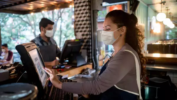 (Mesero y cajera de un restaurante durante la jornada laboral)