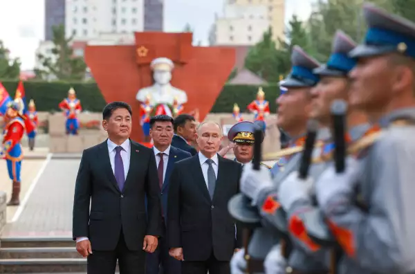 El presidente mongól, Ukhnaagiin Khürelsükh ( 56 años) y el presidente ruso Vladímir Putin (72 años) caminando sobre una explanada, rodeados de soldados mongoles que portan una vestimenta típica.