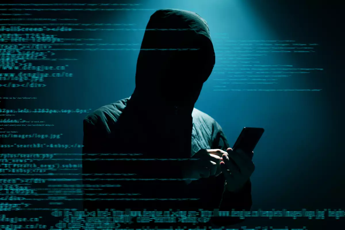 Hacker usando el teléfono en la oscuridad