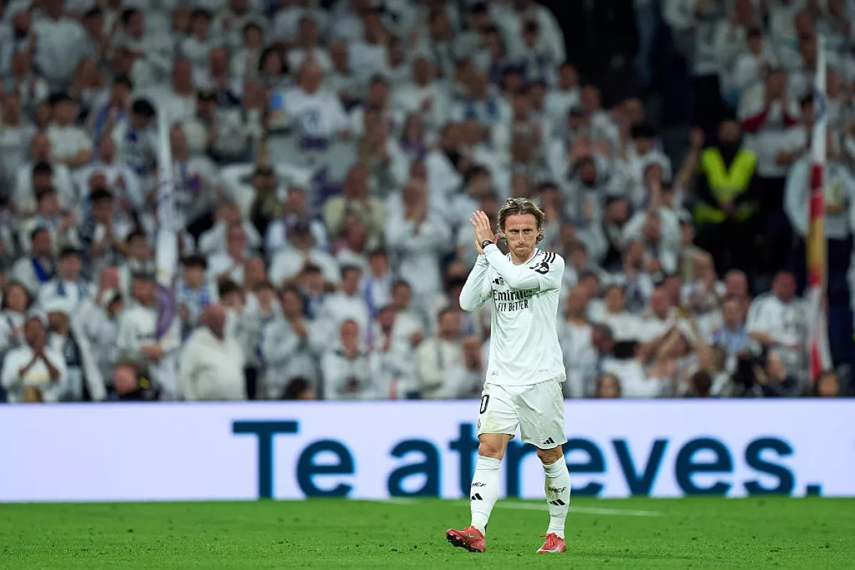 Foto de Luka Modric aplaudiendo en el campo de juego con el uniforme del Real Madrid.