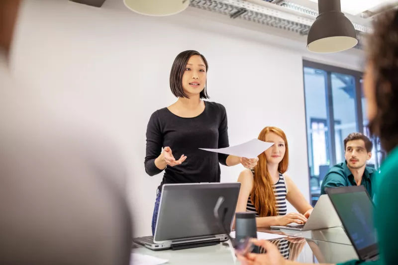 Confident female professional discussing with colleagues