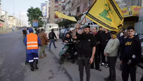 Un hombre sostiene una bandera de Hezbolá, antes de la llegada del Papa León XIV al Líbano durante su primer viaje apostólico, en Haret Hreik, los suburbios del sur de Beirut, Líbano, el 30 de noviembre de 2025.