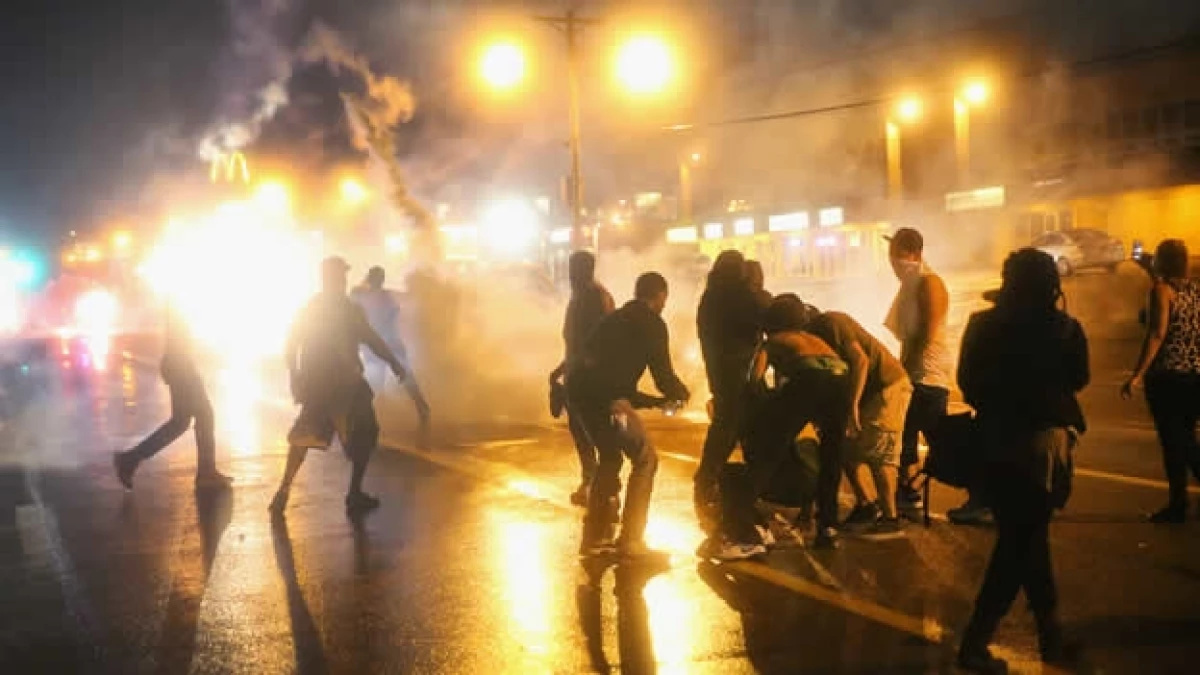Un grupo de manifestantes resiste los ataques de la policía durante una protesta por la muerte de un joven negro en Ferguson