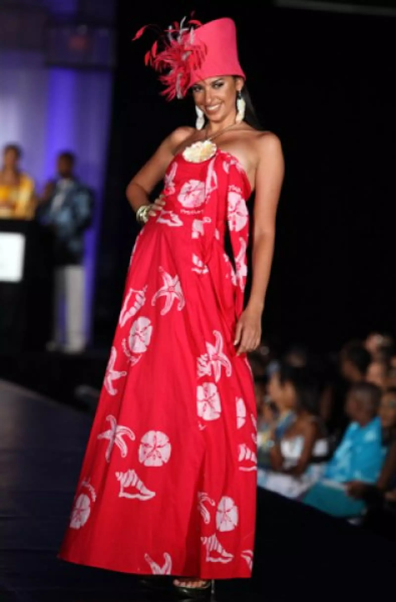 Elham Wagdi, de Egipto, no dejó ver mucha piel con este vestido estraples. Un sombrero rojo con plumas fue el detalle más llamativo.