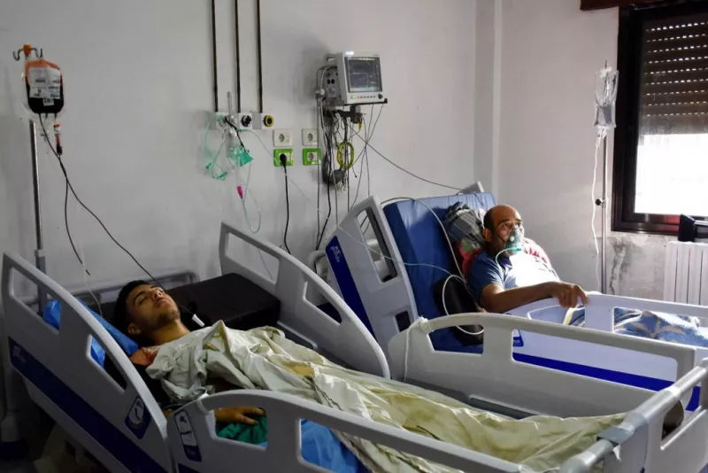Esta foto de cortesía publicada por la Agencia Oficial de Noticias Árabe Siria (SANA) el 5 de octubre de 2023, muestra a personas heridas en el ataque con aviones no tripulados dirigido a una academia militar siria que recibe tratamiento médico en un hospital de Homs controlado por el gobierno.