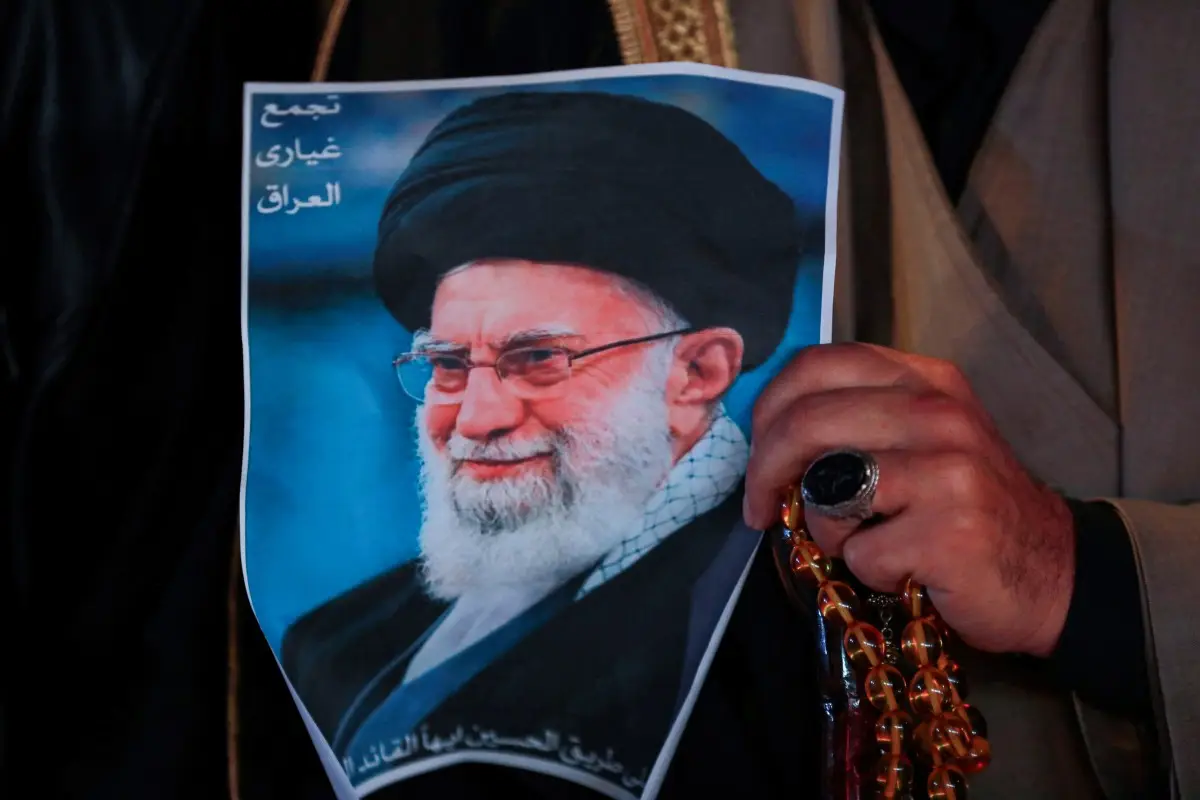 Un hombre musulmán chiíta sostiene un cartel del difunto líder supremo iraní Ayatolá Ali Khamenei, asesinado en un ataque estadounidense-israelí contra Teherán, y un conjunto de cuentas de oración durante un mitin en la Plaza Tahrir, en Bagdad, el 6 de marzo de 2026.