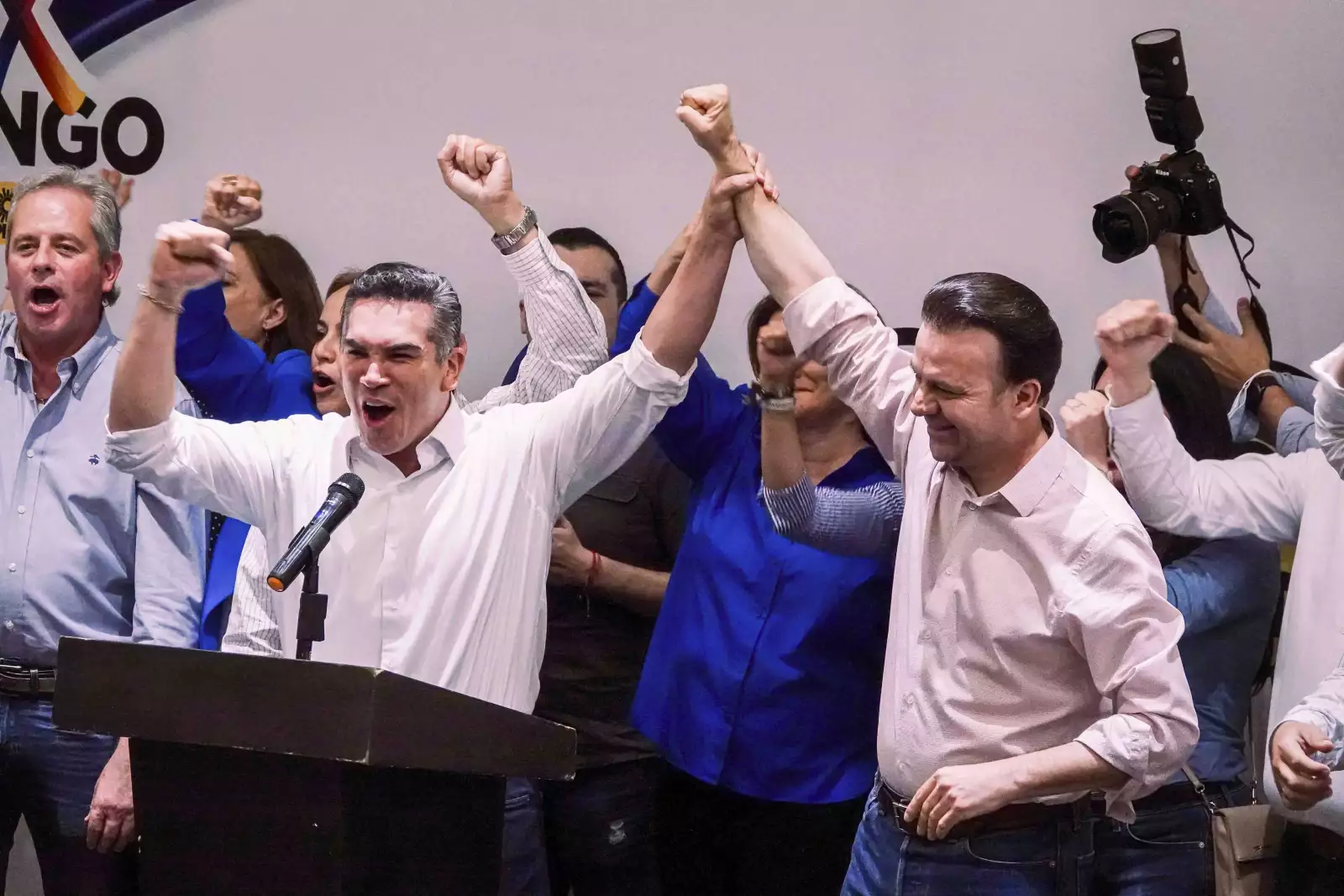 Alejandro Moreno Cárdenas alza el brazo de Esteban Villegas durante la conferencia de prensa en que declararon su triunfo en Durango de acuerdo a las encuestas de salida