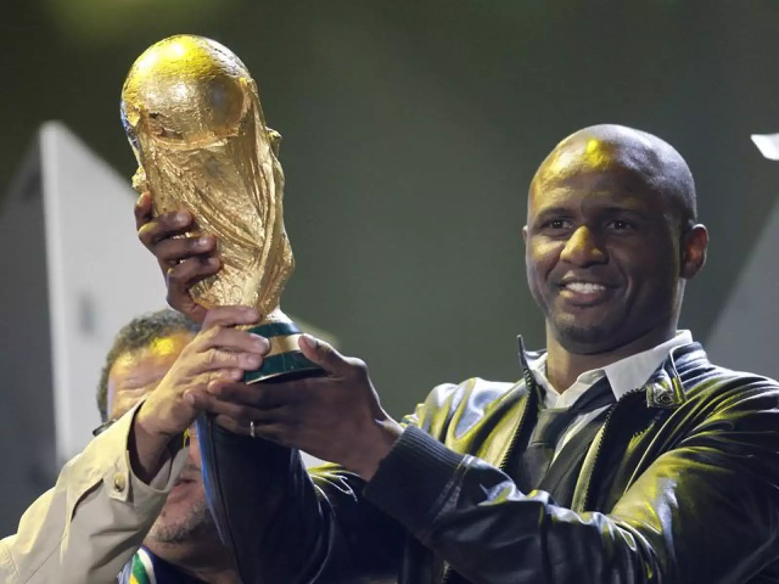 El futbolista francés Patrick Vieira sostiene la copa del Mundo durante el concierto de apertura.