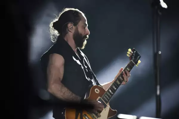 Foto de Jay de la Cueva de perfil con los ojos cerrados y tocando la guitarra