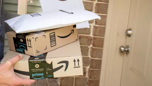 Mensajero entrega paquetes de Amazon en una residencia. 