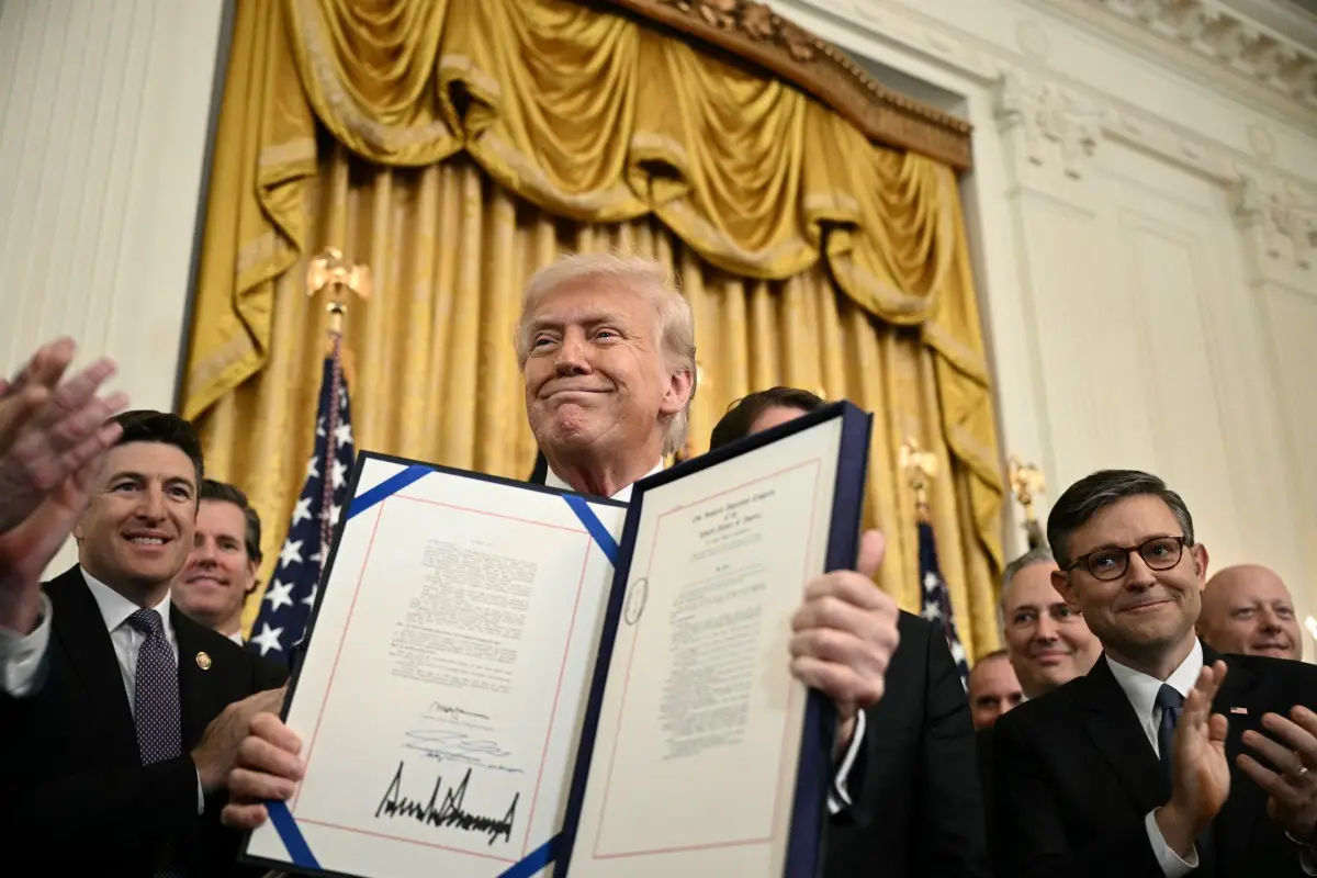El presidente de los Estados Unidos, Donald Trump, muestra la Ley GENIUS (Ley de Orientación y Establecimiento de Innovación Nacional para Monedas Estables de EE. UU.), que codifica el uso de monedas estables, criptomonedas vinculadas a activos estables como el dólar estadounidense o los bonos estadounidenses, después de firmarla en la Sala Este de la Casa Blanca en Washington, DC, el 18 de julio de 2025.
