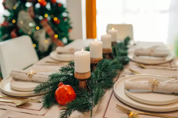 Christmas table setting with candles and pomegranate accent