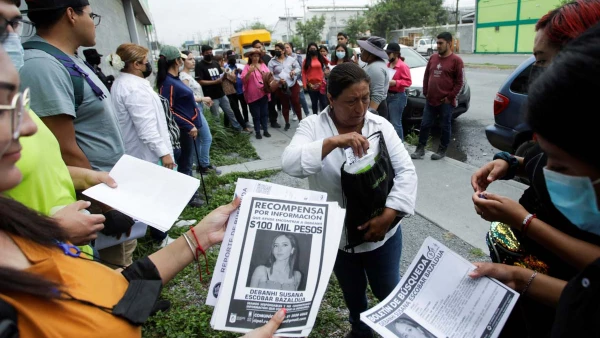 Dolores Bazaldúa, madre de Debanhi Escobar, estudiante de derecho de 18 años desaparecida desde el 9 de abril, entrega afiches a voluntarios con información de su hija, como parte de una búsqueda auxiliada por fuerzas de seguridad, en Escobedo, México