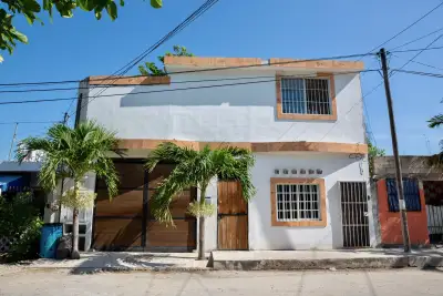 Fotografía de la fachada de una casa blanca en una calle de Tulum, Riviera Maya. 