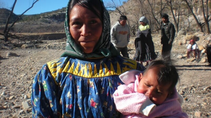 mujer indigena carga a su bebe