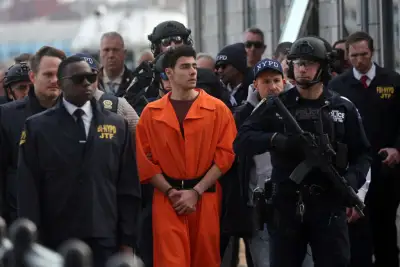 Foto de Luigi Mangione esposado, vistiendo el uniforme anaranjado de prisionero y rodeado de policías poco después de su detención.