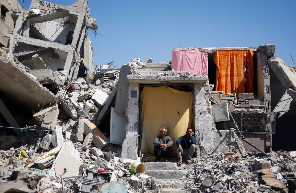 Los palestinos se sientan en su casa que fue destruida en un ataque israelí, en medio del conflicto en curso entre Israel y Hamás, en Khan Younis, en el sur de la Franja de Gaza, el 14 de mayo de 2024.