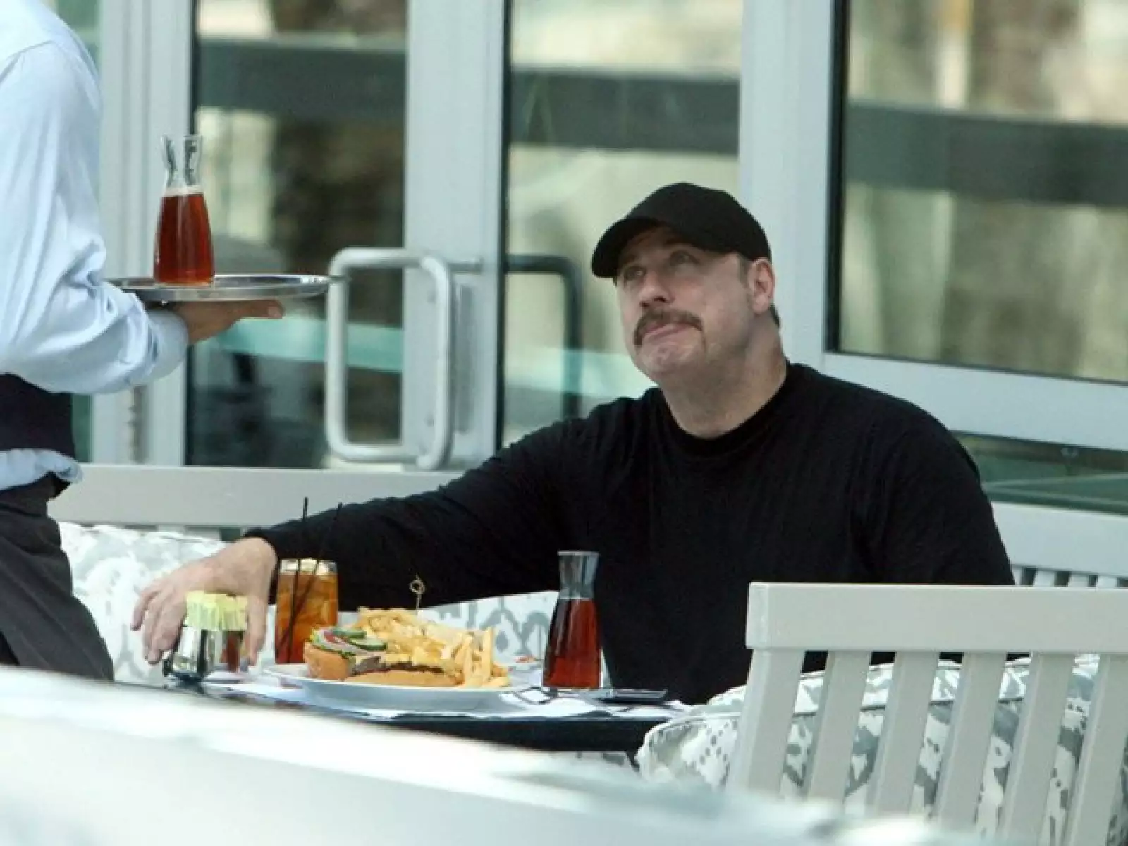 Tan pronto John Travolta bajó de su avión fue a un restaurante, donde pidió una enorme hamburguesa con papas fritas y refresco.