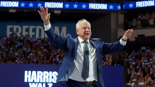 El candidato demócrata a la vicepresidencia, gobernador de Minnesota, Tim Walz, un hombre de más de 60 años, con cabello Branco, vestido con un traje azul, hace un gesto en un mitin de campaña en Milwaukee, Wisconsin, EE. UU., el 20 de agosto de 2024.