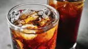 Cola soft drink with ice cubes, Close up of soda fizzy drink in Cold glass on gray background