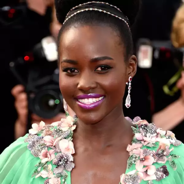 Para la premiere de La Tete Haute, Luptia Nyongo llevó un ballerina bun extra grande y extra glamouroso. Los labios morados hicieron que el vestido verde luciera aún más espectacular.