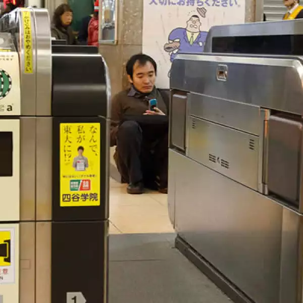 Un hombre se sienta en el suelo de una estación de trenes, luego de que los servicios de metro fueron suspendidos.