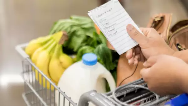 Unrecognizable woman checks items off grocery list