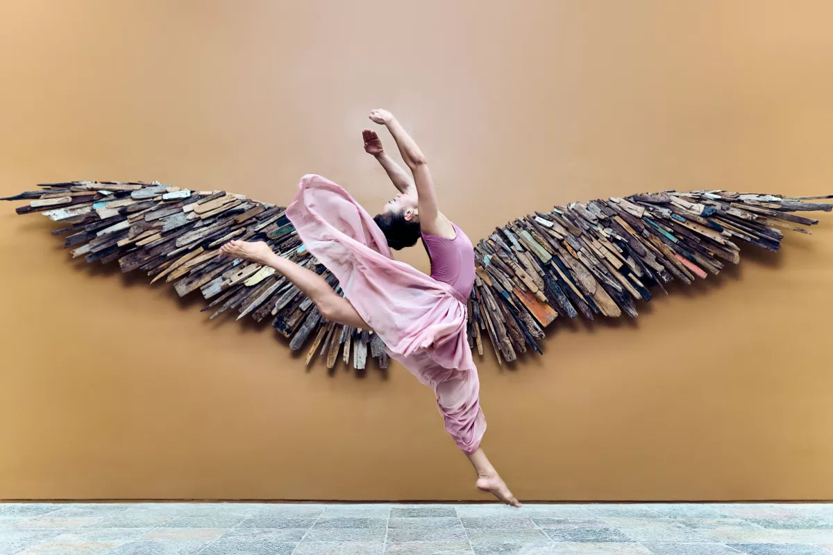 Salto de bailarina con fondo de alas y pared amarilla