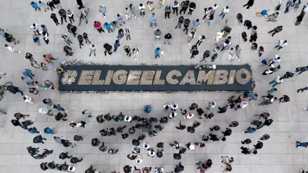 Una multitud rodea las palabras Elige El cambio, que son el mensaje que lanza Philip Morris International invitando a que la gente elija dejar de fumar u optar por productos IQOS, sin humo, que solamente calientan el tabaco