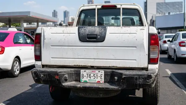 arte trasera de una camioneta pick-up blanca circulando en la Ciudad de México, con la defensa y la zona inferior del vehículo visibles.