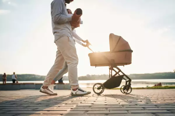 Couple with a baby pram is walking together