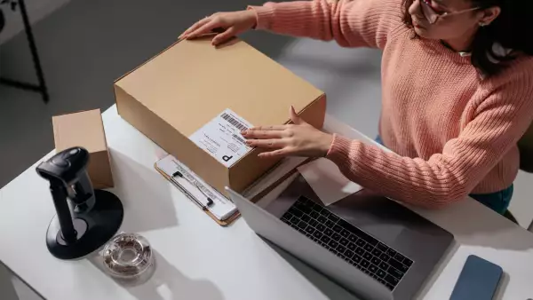 Person handling a box at a modern desk
