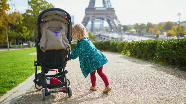 Adorable niña pequeña caminando cerca de la Torre Eiffel en París, Francia. Niño feliz disfrutando del día de otoño. Actividades de otoño al aire libre para niños