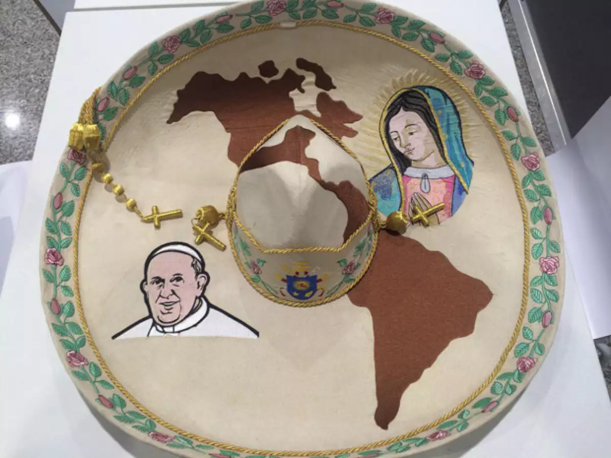 El sombrero tiene las imágenes de Juan Pablo II y la Virgen de Guadalupe.
