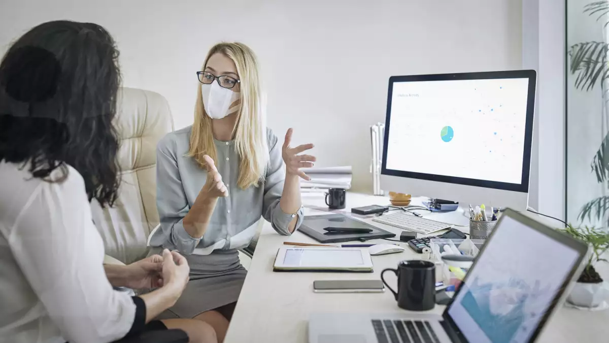Businesswoman in medical mask explaining her idea