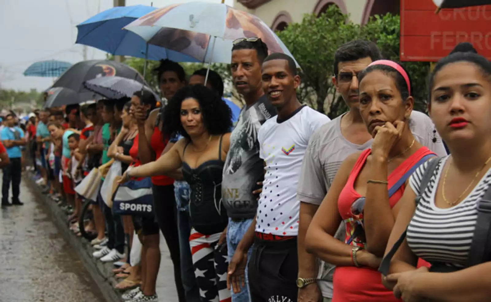 Decenas de cubanos desafiaron las inclemencias del clima y aguardaron el paso de la caravana presidencial en su camino hacia La Habana Vieja