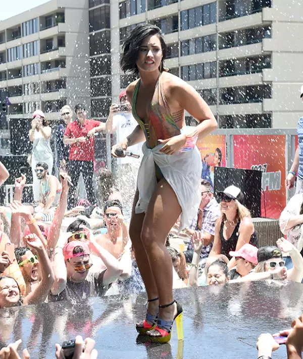Demi lució su sexy figura en un traje de baño multicolor y altos zapatos.