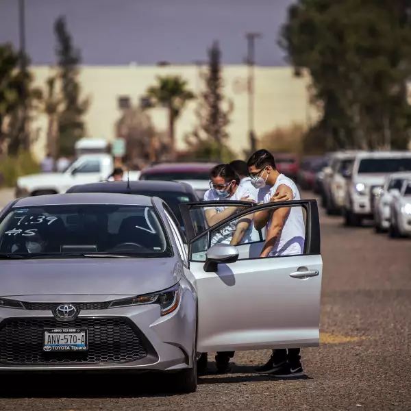 Mexicanos tras ser vacunados en la Universidad de Baja California 