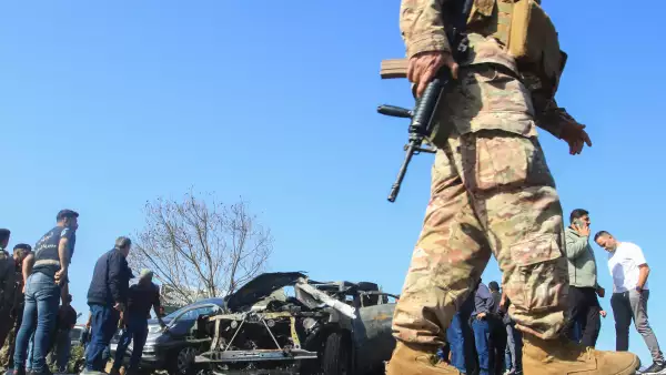 Varias personas inspeccionan un vehículo calcinado que, al parecer, fue alcanzado por un ataque israelí en Ghazieh, cerca de Sidón, el 18 de abril de 2025.