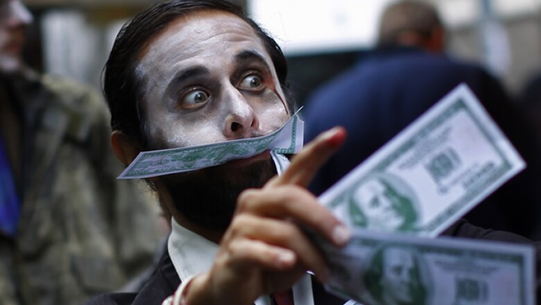 Integrantes del movimiento Occupy Wall Street (Ocupemos Wall Street) se disfrazaron de zombies y fingieron devorar dinero para que los ejecutivos financieros vieran una metáfora de sus acciones.