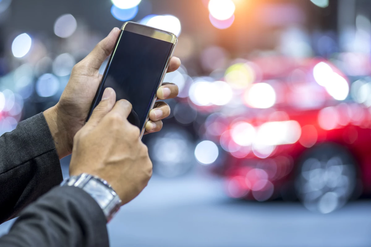 hands using digital smartphone with intelligent car