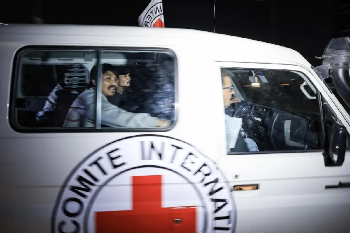 Un vehículo de la Cruz Roja Internacional que transporta rehenes liberados por Hamas conduce hacia el punto fronterizo de Rafah con Egipto antes de su traslado a Israel el 26 de noviembre de 2023. El ejército israelí dijo en un comunicado el 26 de noviembre de 2023 que 13 rehenes liberados estaban de vuelta en territorio israelí, y otros cuatro estaban en camino a través del cruce de Rafah entre la Franja de Gaza y Egipto.