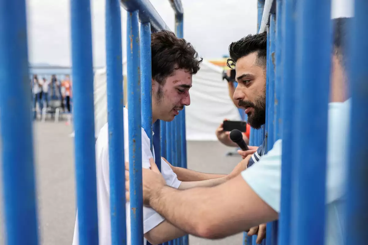 El sobreviviente sirio Mohammad, de 18 años, que fue rescatado con otros refugiados y migrantes en mar abierto frente a Grecia después de que su barco volcara, llora mientras se reúne con su hermano Fadi, que vino a reunirse con él desde los Países Bajos, en el puerto de Kalamata, Grecia, el 16 de junio de 2023. REUTERS/Stelios Misinas