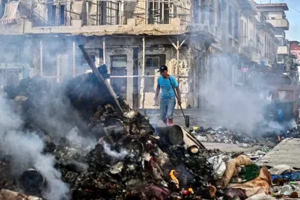 Un hombre camina cerca de un incendio en una basura ubicada en una calle de La Habana el 14 de julio de 2026.